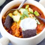 Healthy Butternut Squash and Turkey Chili in bowl with avocado, sour cream, and chips.