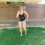 girl standing in backyard with amargarita glass black tank top and baeigh short