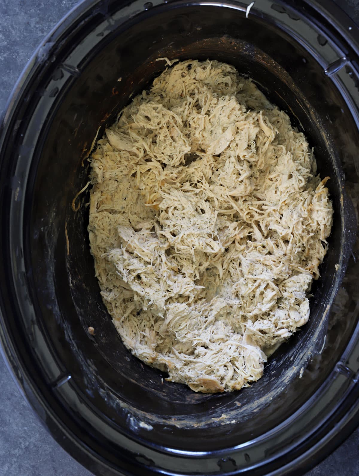 Crockpot crack chicken with shredded chicken mixed into creamy ranch sauce